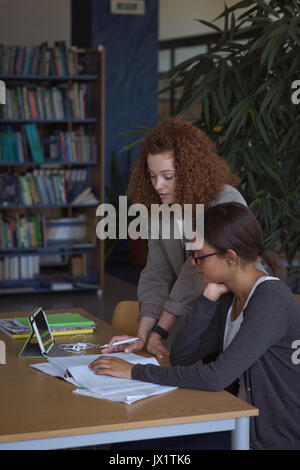 Female students studying at desk in classroom Stock Photo