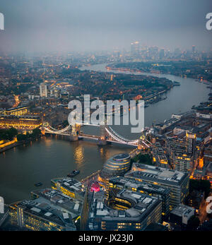 View of River Thames towards Canary Wharf, illuminated Tower Bridge with London City Hall, dusk, aerial view, London, England Stock Photo