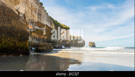 Sandstone rocks towering into the sea, Tunnel Beach, Otago, South Island, New Zealand Stock Photo