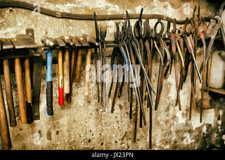 Blacksmith tools in workshop different pliers and hammers Stock Photo