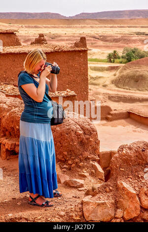 Pregnant woman taking photos inside  Ait Benhaddou, an ancient fortress city in Morocco near Ouarzazate on the edge of the sahara desert. Stock Photo