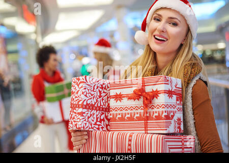 Amused woman with a pile of Christmas presents Stock Photo