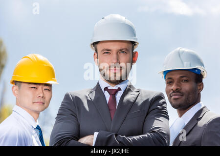 portrait of multiethic group of professional architects in hard hats, successful businessmen Stock Photo