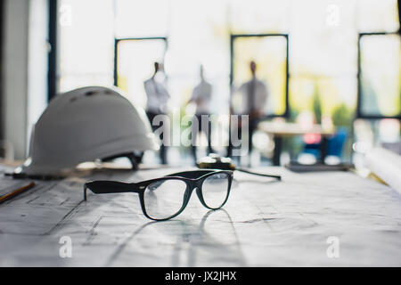 various architecture supplies on workplace with architects behind, focus on foreground  Stock Photo