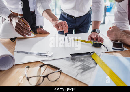 partial view of team of architects working on plan together in modern office Stock Photo