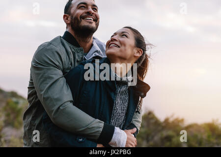 Romantic young couple embracing in nature. Happy young man and woman on vacation in countryside. Stock Photo