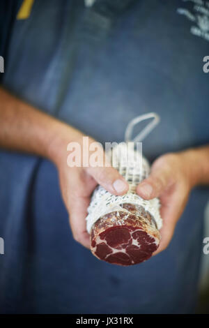Man holding large salami Stock Photo