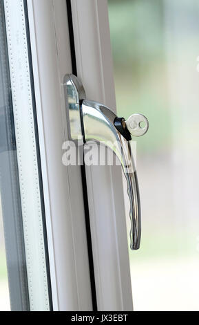 lockable window handle on white plastic frame Stock Photo