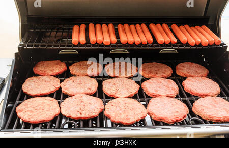 spray petroleum død Hamburger Patties and Hot Dogs Cooking on a New Gas Grill Stock Photo -  Alamy