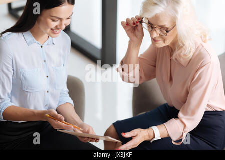 Pleasant young assistant showing her boss a document Stock Photo