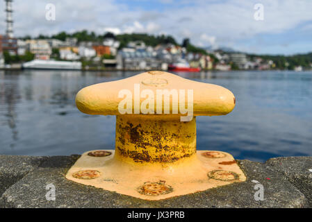 Yellow harbor mooring on the background of the summer marina on a sunny day. Stock Photo