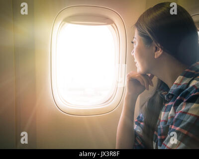 photo of sweet lady seriously view scenery of sunset sky. traveler sitting on the comfortable cabin seat looking out concept. Stock Photo