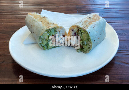 Chicken salad sandwich wrap sliced served on white plate Stock Photo
