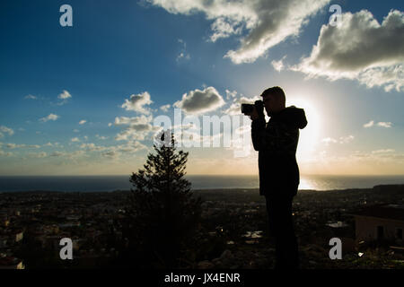 Travel, vacation, photographer and hitchhiker concept - Silhouette of traveler man photographed nature Stock Photo