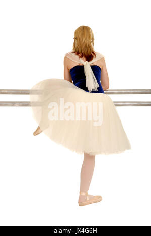 A Ballerina in Costume Takes a Break and Rests on Ballet Barre Stock Photo