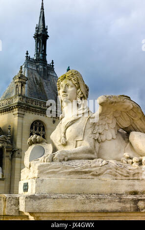 Sphinx statue in front of Palace of Chantilly in golden afternoon light Stock Photo