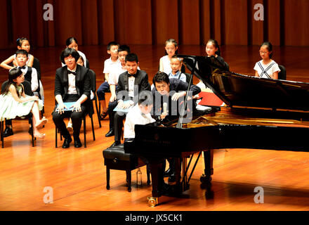 Beijing, China. 15th Aug, 2017. Chinese pianist Lang Lang instructs a boy at the National Centre for the Performing Arts (NCPA) in Beijing, capital of China, Aug. 14, 2017. Lang Lang gave a master class in NCPA during which he shared his stories and piano skills with children on Monday. Credit: Xinhua/Alamy Live News Stock Photo