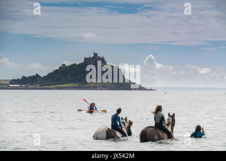 Longrock, near Marazion, Cornwall. 15th August 2017. UK Weather. The sunshine came out this afternoon in south west cornwall. Out in mounts bay people were swimming on horses, including Mea Sucato who flew from New York to Cornwall especially for a birthday treat of going into the waters off Long rock, in front of the iconic St Michaels Mount. Mea is on the right hand horse. Credit: Simon Maycock/Alamy Live News Stock Photo