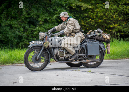 German WW2 soldiers riding on BMW military motorcycle with sidecar during World War Two re-enactment Stock Photo