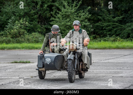 German WW2 soldiers riding on BMW military motorcycle with sidecar during World War Two re-enactment Stock Photo