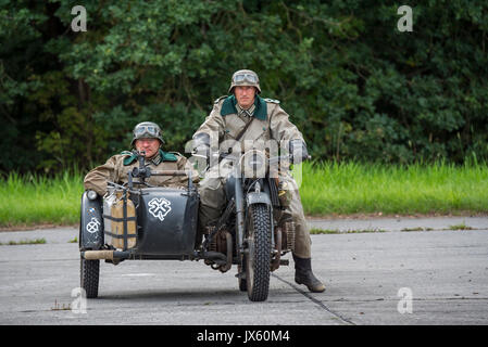 German WW2 soldiers riding on BMW military motorcycle with sidecar during World War Two re-enactment Stock Photo