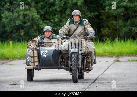 German WW2 soldiers riding on BMW military motorcycle with sidecar during World War Two re-enactment Stock Photo