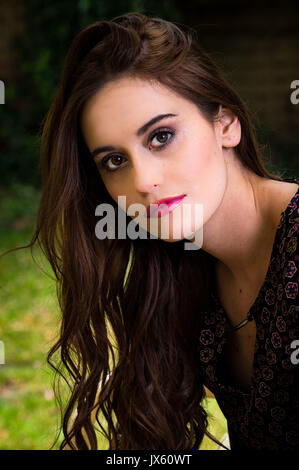 Portrait of an attractive girl sitting in the garden Stock Photo - Alamy