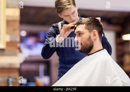 man and barber cutting hair at barbershop Stock Photo