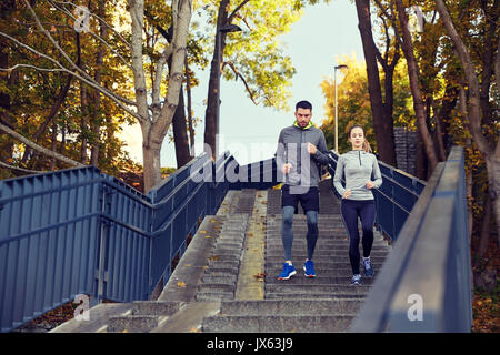 happy couple running downstairs in city Stock Photo