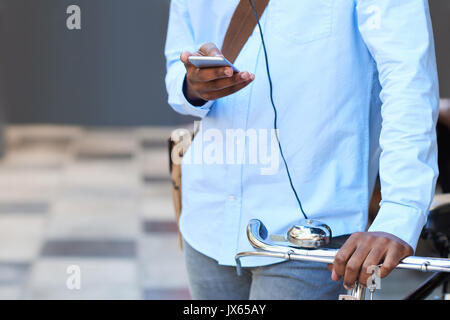 Closeup of a man with his bike using a cellphone Stock Photo