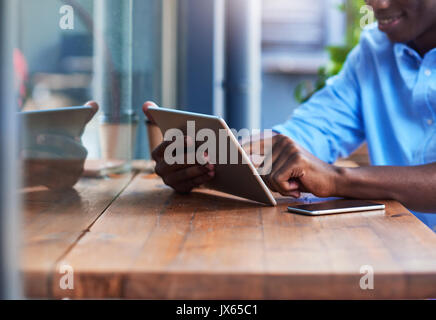 Young man working online at a sidewalk cafe counter Stock Photo