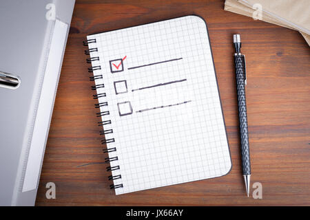 Book with blank checklist on wooden table. Stock Photo