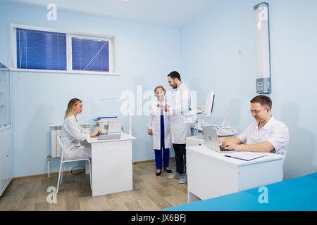 Group Of Doctors Involved In Serious Discussion With Medical Records Stock Photo