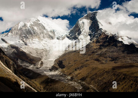 A mountain range is partially covered by clouds in Peru's region of Huaraz Stock Photo