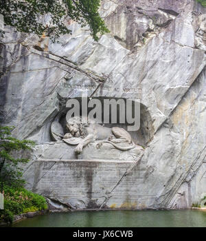 Dying lion monument (German: Lowendenkmal) carved on the face of stone cliff with the pond in the foreground in Luzern, Switzerland, Europe. Stock Photo