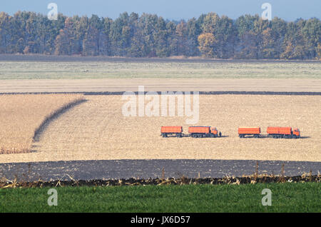 Agricultural machines after doing agricultural seasonal work in the field after harvesting under dramatic beautiful autumn day. In the distortion of t Stock Photo