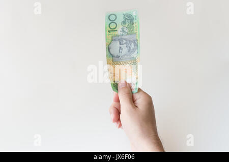 Man holding one hundred Australian Dollar banknote in his hand Stock Photo