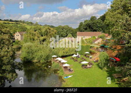 Bradford on Avon, UK - AUGUST 12, 2017: People relaxing in a Pub Garden beside the river Avon in Avoncliff (picture taken from Avoncliff Aqueduct) Stock Photo