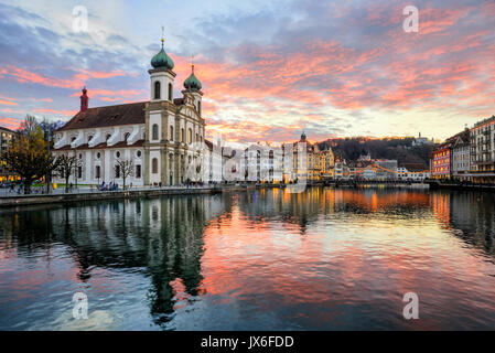 Dramatic sunset reflecting in river over historical old town of Lucerne, Switzerland Stock Photo