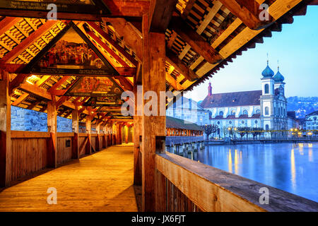 Lucerne, Switzerland - December 28: Historical Chapel Bridge, decorated with medieval paintings, is the oldest wooden covered bridge in Europe. Old To Stock Photo
