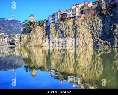 Metekhi Church and traditional houses on a steep rock reflecting in Kura River, Tbilisi Old Town, Georgia Stock Photo