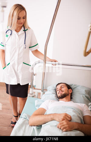 Sick Patient in hospital room next to nurses Stock Photo