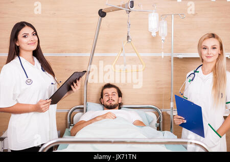 Patient in hospital room next to nurses Stock Photo