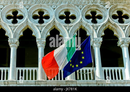 Italian and European flags at Doge’s Palace, Venetian Gothic style. Saint Marks Square. UNESCO. Palazzo Ducale, Piazza San Marco. Venice, Italy Europe Stock Photo