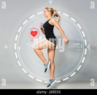 young woman in black sportswear jumping with pulse Stock Photo