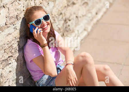 happy young woman or girl calling on smartphone Stock Photo