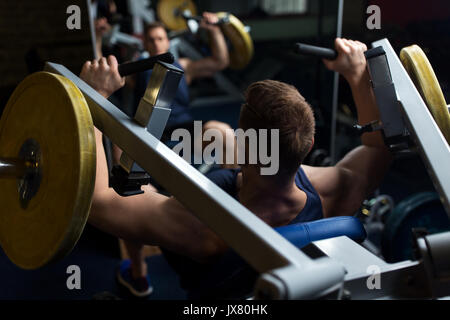 man doing chest press on exercise machine in gym Stock Photo