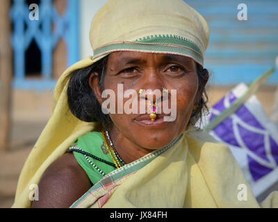 Indian Adivasi woman with two nose studs and nose-septum jewellery poses for the camera. Stock Photo