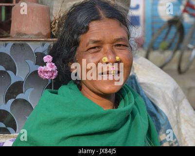 Indian Adivasi woman with two nose studs and nose-septum jewellery smiles for the camera. Stock Photo