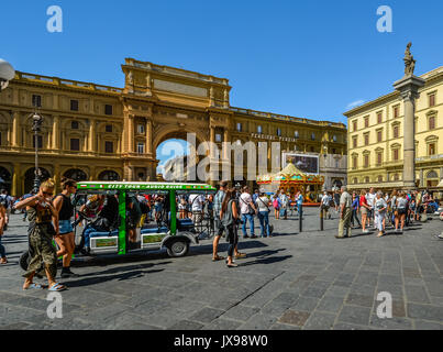 Piazza della Repubblica in Florence Italy crowded with tourists, a tourist city tour bus and a carousel on a summer day Stock Photo